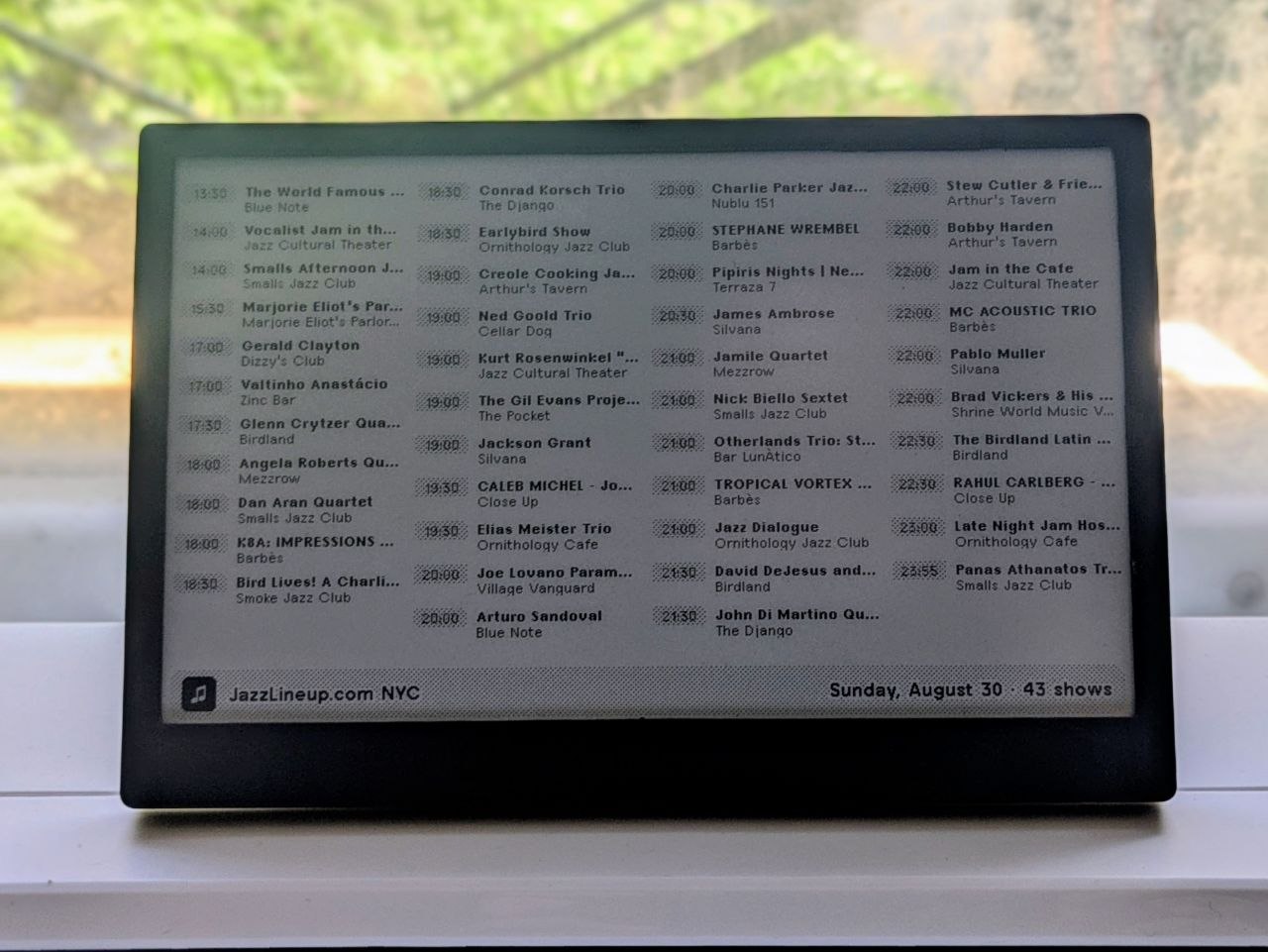 A TRMNL e-ink display on a windowsill shows JazzLineup.com's New York jazz listings.